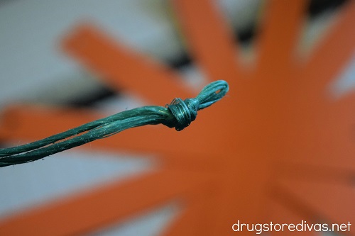 A knot tied at the bottom of a piece of green twine.