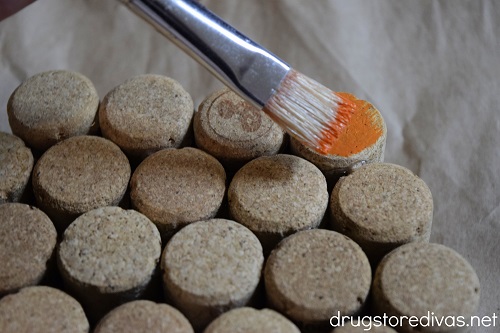 A paint brush painting wine corks.