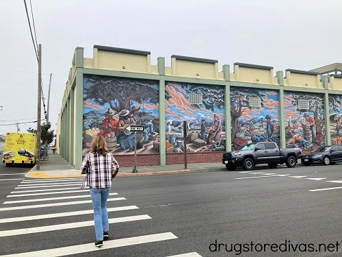 A woman walking past a mural in Eureka, CA.