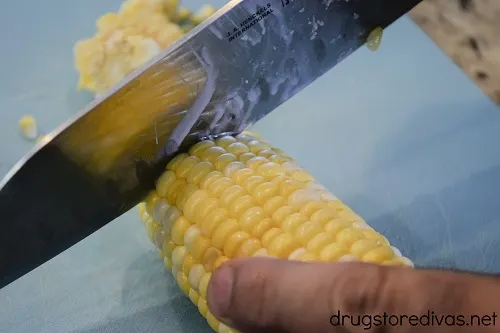 The ends being cut off an ear of corn.