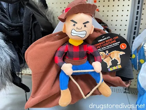 A cowboy ride on pet costume for sale on a shelf.