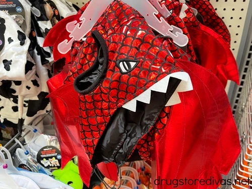 A red dragon pet costume on a shelf.