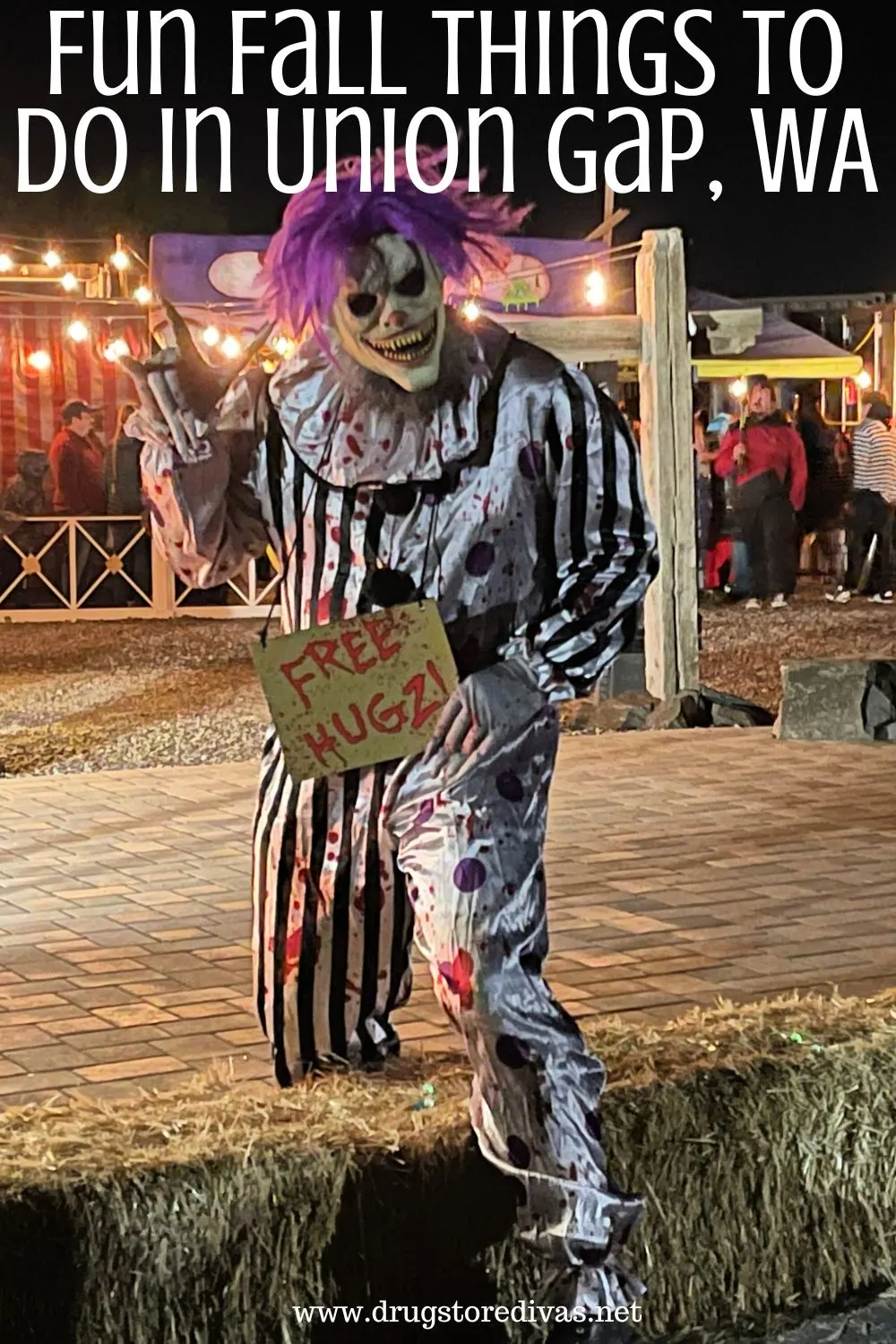 An actor in a scary clown Halloween costume holding a sign that says 