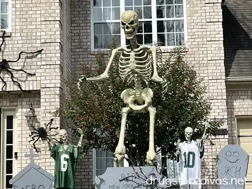 A giant 12-foot skeleton surround by tombstones and smaller skeletons in New York Jets jerseys.
