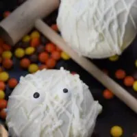 Two homemade mummy chocolate bombs with a wooden hammer and the words 