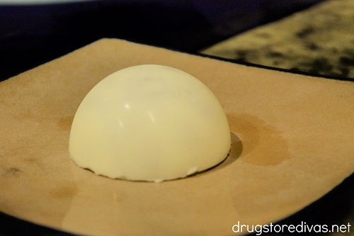 A white chocolate dome on a plate.