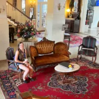 A woman sitting in the haunted Belmont Inn with the words 