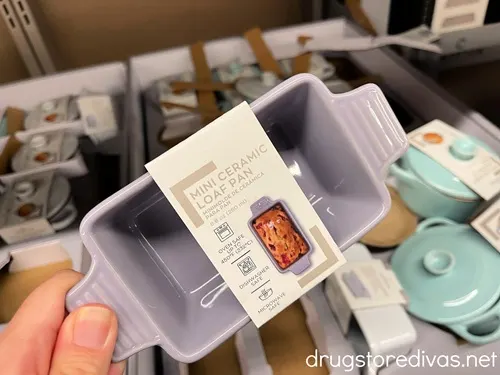 A hand holding a mini loaf pan that's purple.