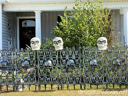 A Halloween fence with skulls on it.