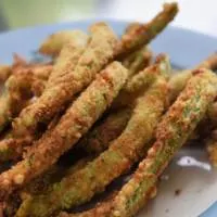 Green bean fries on a plate with the words 
