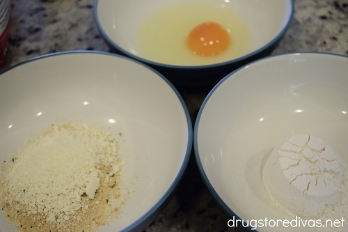 A bowl with a panko/parmesan mixture, a bowl with an egg, and a bowl with flour.