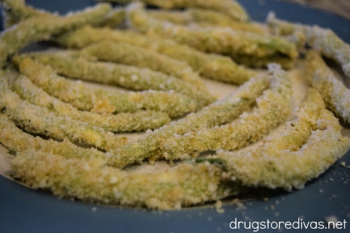 Raw panko and parmesan green bean fries on a plate.