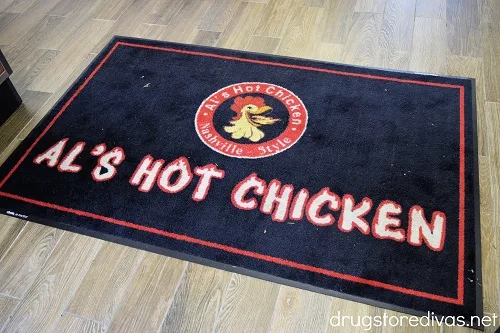 A rug that says Al's Hot Chicken.