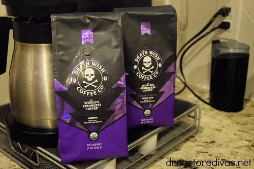 Two bags of Death Wish Coffee next to a coffee maker and coffee grinder.
