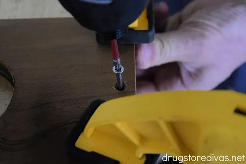A screw being drilled into wood.