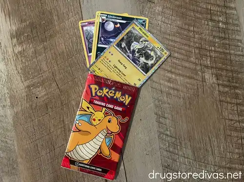 Three Pokemon cards coming out of a card envelope with Dragonite on it.