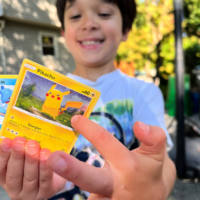 A boy holding Pokemon cards with the words 
