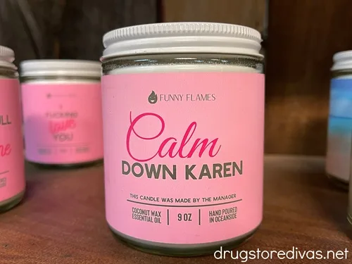A candle with a pink wrapper that says Calm Down Karen on it.