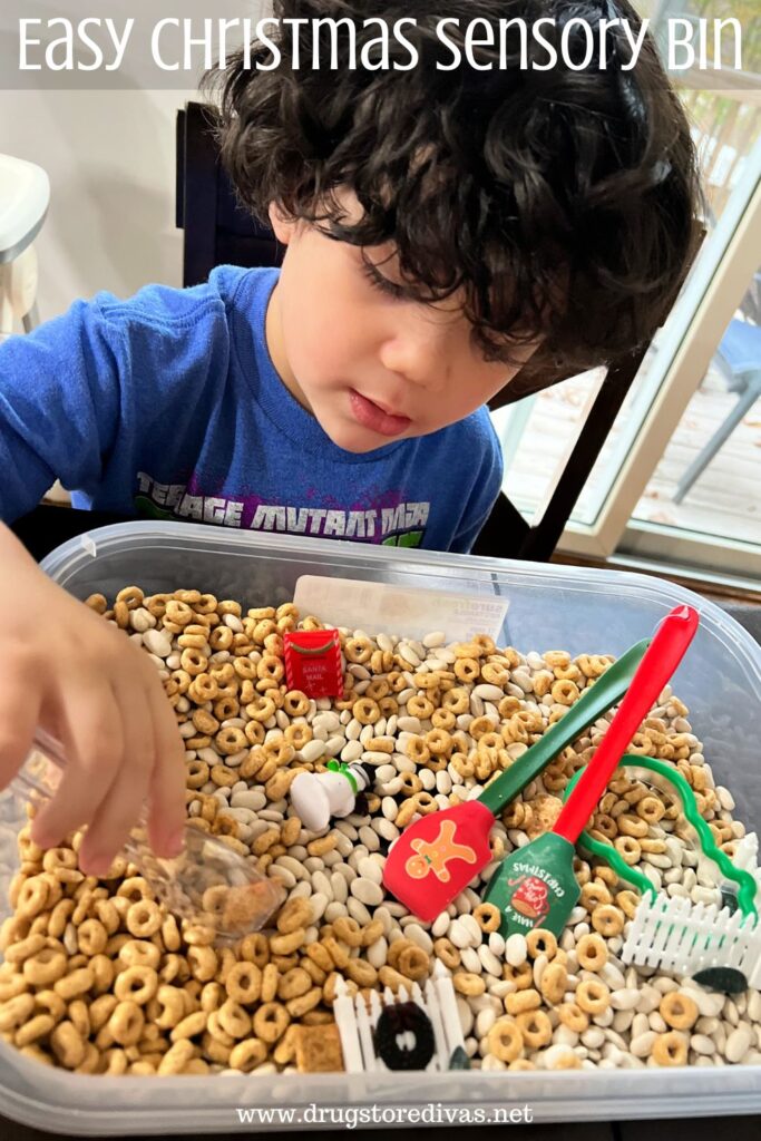 A young boy playing in a sensory bin with the words "Easy Christmas Sensory Bin" digitally written above him.