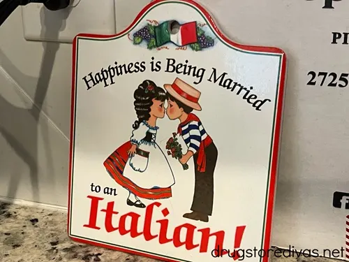 A metal sign with a couple on it that says Happiness Is Being Married To An Italian.