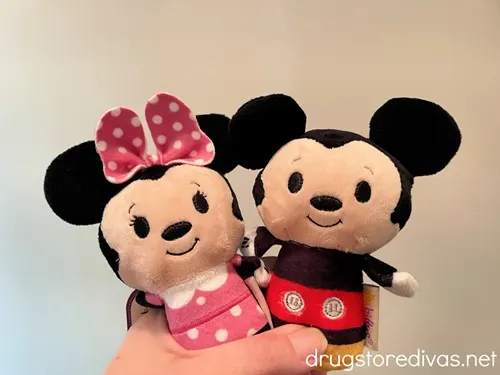 A hand holding a Minnie Mouse and a Mickey Mouse Itty Bitty from Hallmark.