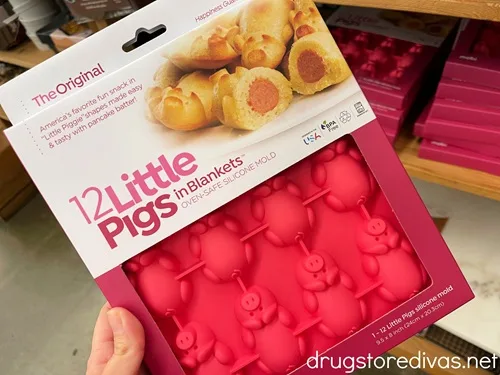 A hand holding a silicone pigs in a blanket maker.