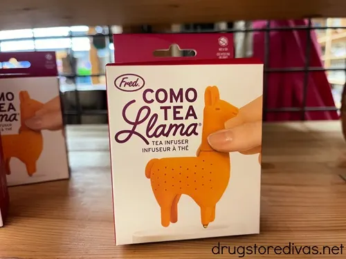 A llama shaped tea infuser in a box on a shelf.