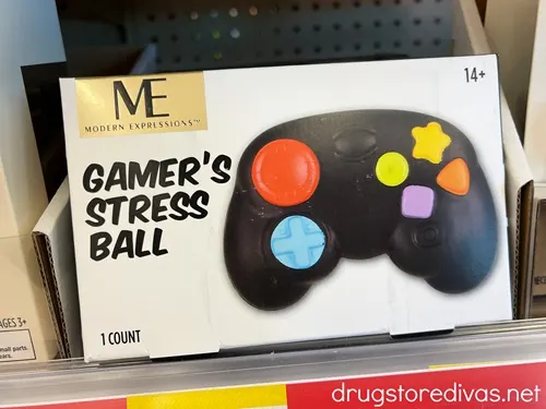 A box on a shelf that says Gamer's Stress Ball and has an image of a stress ball shaped like a video game controller next to it.