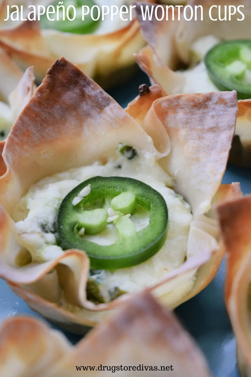 Filled wonton wrappers on a tray with the words 