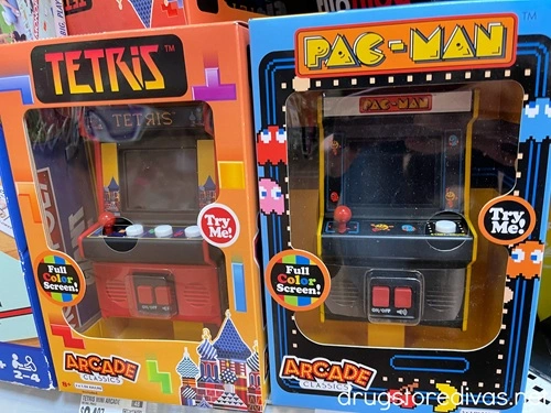 Two mini arcade games -- Tetris and Pacman -- in boxes on a shelf in a store.