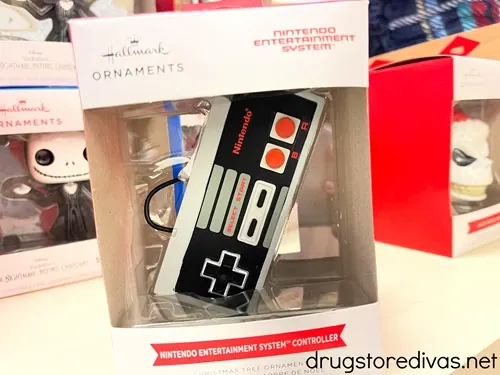 A Nintendo controller ornament in a box on a shelf.