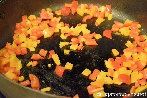 Red and orange pepper pieces in a skillet.