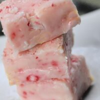 Three pieces of pink fudge with the words 