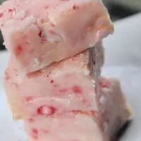 Three pieces of pink fudge with the words 