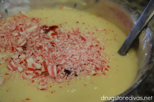 Crushed candy canes on top of melted white chocolate in a bowl.