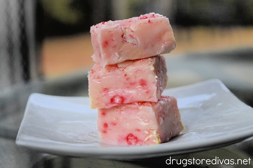 Three pieces of candy cane fudge on top of each other on a plate.