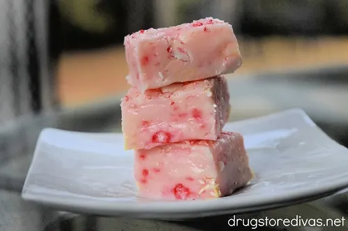 Three pieces of candy cane fudge on top of each other on a plate.