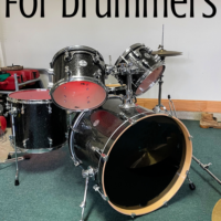A drum set in a garage with the words 