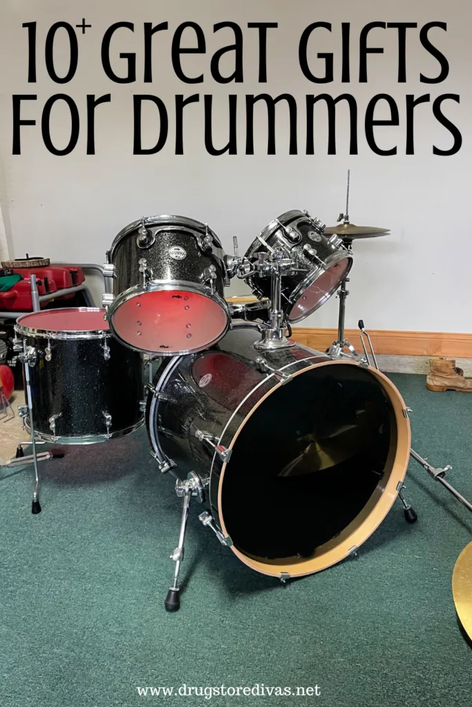 A drum set in a garage with the words "10+ Great Gifts For Drummers" digitally written above it.