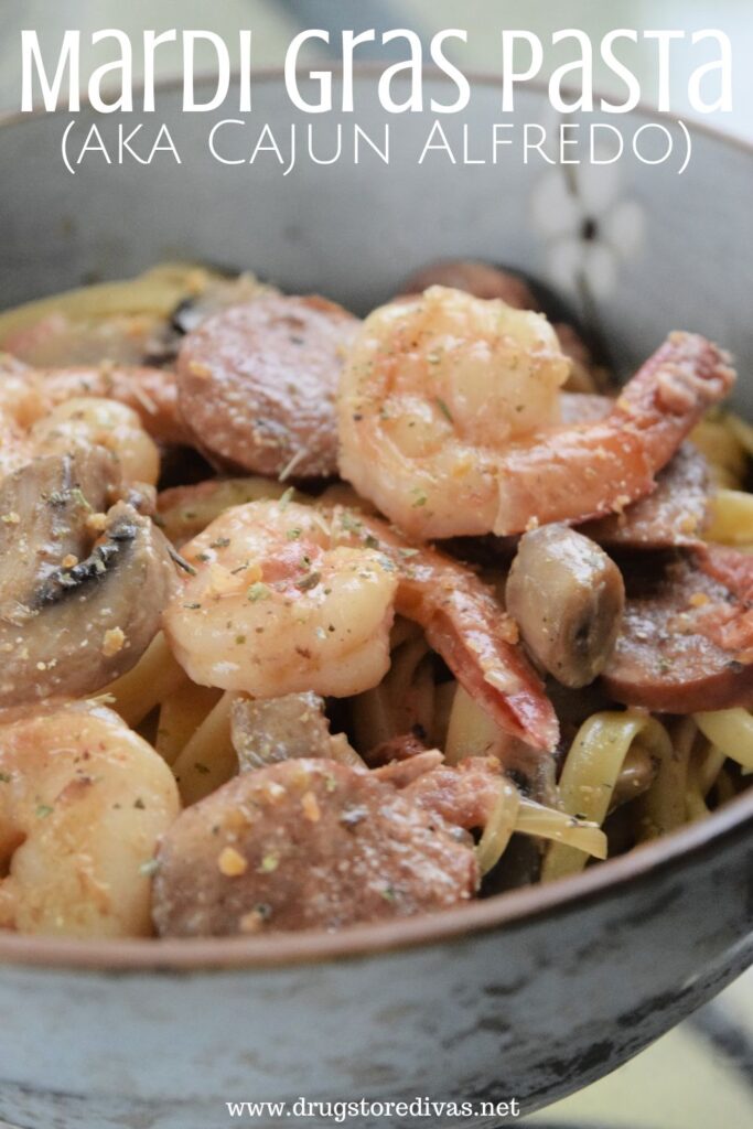 Shrimp, sausage, mushrooms, and pasta in a bowl with the words "Mardi Gras Pasta (aka Cajun Alfredo)" digitally written on top.