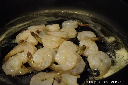 Raw shrimp cooking in a skillet.