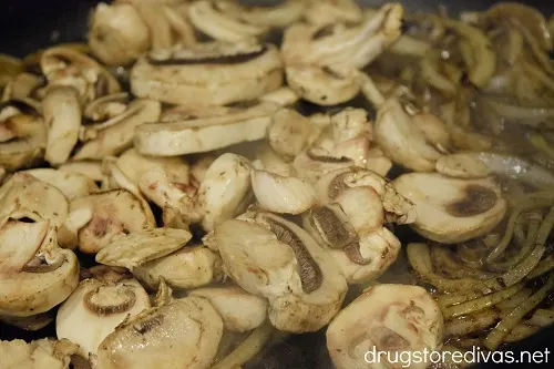 Sliced mushroom and onion in a pan.
