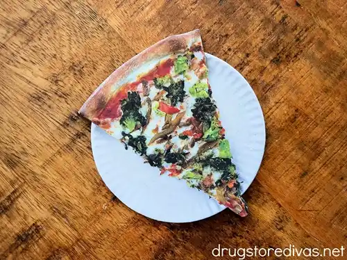 A coaster that's shaped like a slice of pizza on a paper plate.