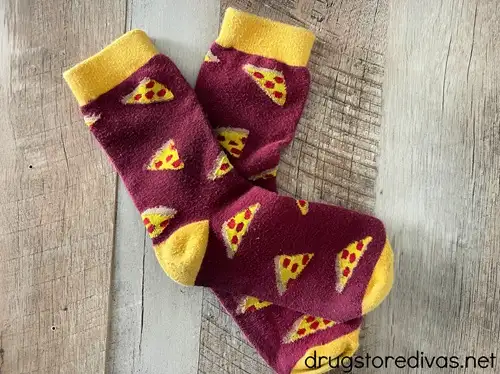 A pair of maroon socks with pizza slices on them.