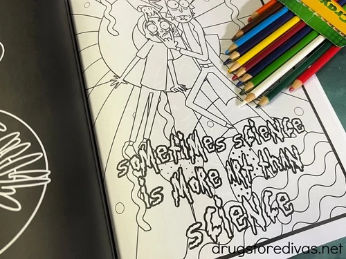 A coloring book opened to a page with an open box of colored pencils on top.