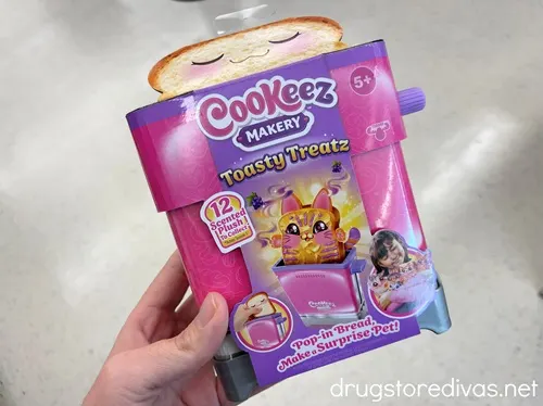 A hand holding a Cookeez Makery Treatz toy.
