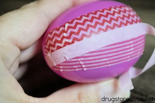 Three pieces of washi tape on a plastic Easter egg.