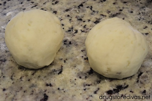 Two dough balls on a counter.