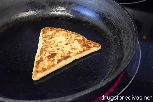 A triangle-shaped piece of dough in a pan.