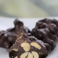 Three peanut clusters on a plate, with one cut in half, and the words 
